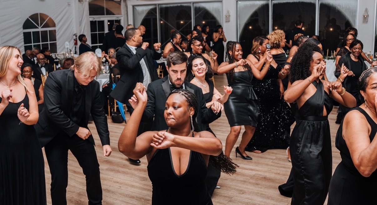 Packed dance floor of guests grooving at an elegant tented wedding reception